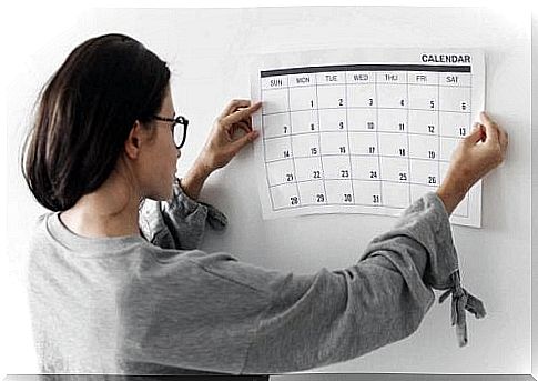 Woman putting a calendar on the wall