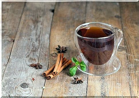 Cinnamon sticks next to a cup of tea