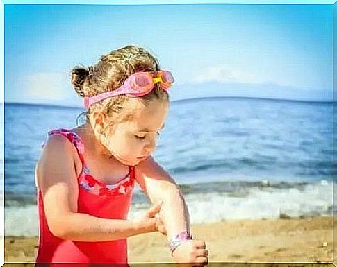 Little girl at the beach in a bathing suit